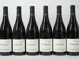 six bouteilles de vin rouge sont alignées sur une surface blanche