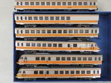six trains dans une boîte bleue posée sur une surface blanche