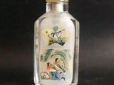 une bouteille en verre décorée d'une peinture, posée sur une table