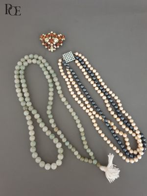 un ensemble composé de trois colliers en perles et d'une broche
