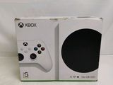 the box of a white xbox game console sitting on top of a white table