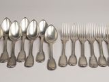 a lot of spoons and forks on the table