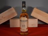 a bottle of whisky sitting on a table next to a wooden box