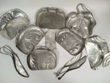 several pieces of silver metal are arranged on a white surface