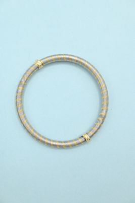 a close up of a gold bracelet on a blue surface