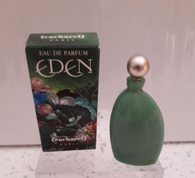 un flacon de parfum posé sur une table à côté d'une boîte
