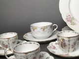 a lot of cups and saucers sitting on a table