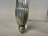 a silver vase that is sitting on a table