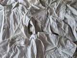 un tas de vêtements blancs posé sur un lit