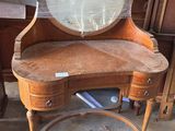 a wooden vanity with a mirror on top of it