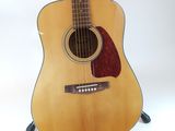 an acoustic guitar sitting on a stand against a white background