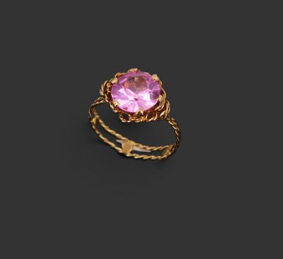 une bague en or sertie d'une pierre rose sur fond noir