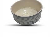 a small bowl with a pattern on it on a white surface