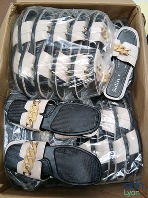 several pairs of sandals in a box on a table