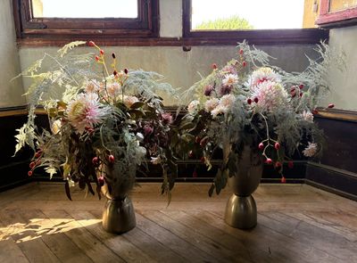 deux vases posés par terre, dans lesquels se trouvent des fleurs