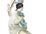 a figurine of a woman sitting on a chair