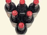 several bottles of wine are arranged in a triangle on a white surface