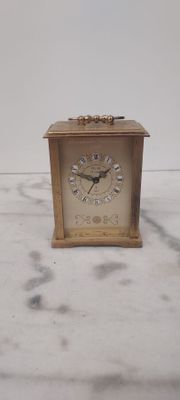 une petite horloge posée sur un plan de travail en marbre