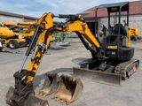 the back end of a small excavator parked in a parking lot