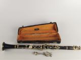 a black and gold clarinet with a case on the table