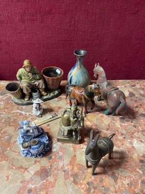 many figurines sitting on a table next to a vase