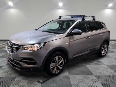 le SUV argenté est garé sur le sol en damier d'un garage