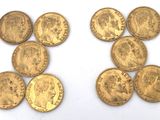 a close up of a number of gold coins on a white surface