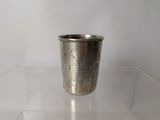 a silver cup that is sitting on a clear table