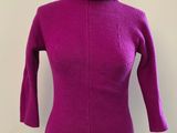 pull à col roulé violet sur un mannequin de vitrine