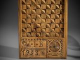 a carved wooden panel with geometric designs and numbers