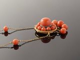 an image of a necklace with coral beads on a black surface