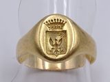 a picture of a gold ring with a coat of arms and a crown on it