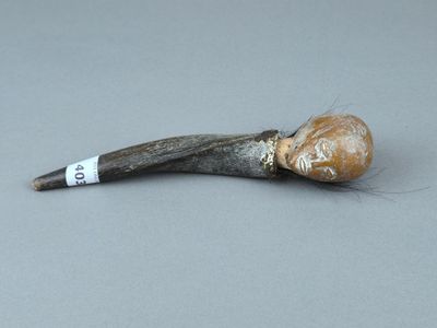 une vieille pipe d'où sort un bâton