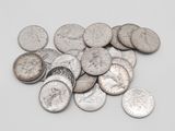 tas de pièces d'argent posées sur une surface blanche, sur fond blanc