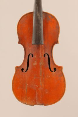 un vieux violon posé sur une surface blanche