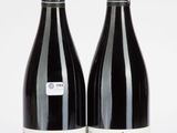 deux bouteilles de vin rouge posées l'une à côté de l'autre sur une surface blanche