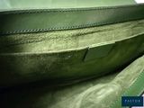 a close up of a green purse on a table