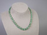 un collier de perles vertes sur un mannequin d'exposition