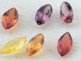 five different colored gems are arranged in a row on a white surface