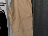 a tan pants hanging on a rack in a closet