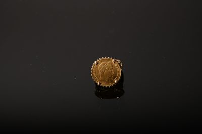 a close up of a gold coin sitting on top of a black surface