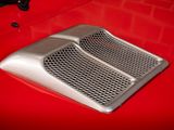 a close up of a red car ' s hood vent
