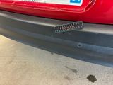 a remote control attached to the bumper of a red car