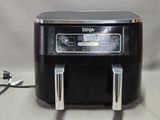a black and silver air fryer sitting on a table