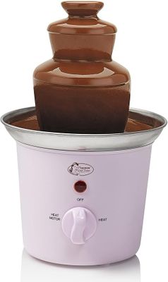 un gros plan d'une fontaine à chocolat dans un bol posé sur une surface blanche