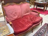 un canapé rouge placé dans une pièce où il y a un tapis au sol
