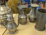 a lot of silver vases on a table in a room
