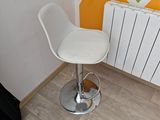 un tabouret de bar blanc posé devant un radiateur