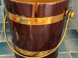 a wooden bucket sitting on a tiled floor in a bathroom