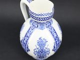 an old blue and white pitcher on a black background